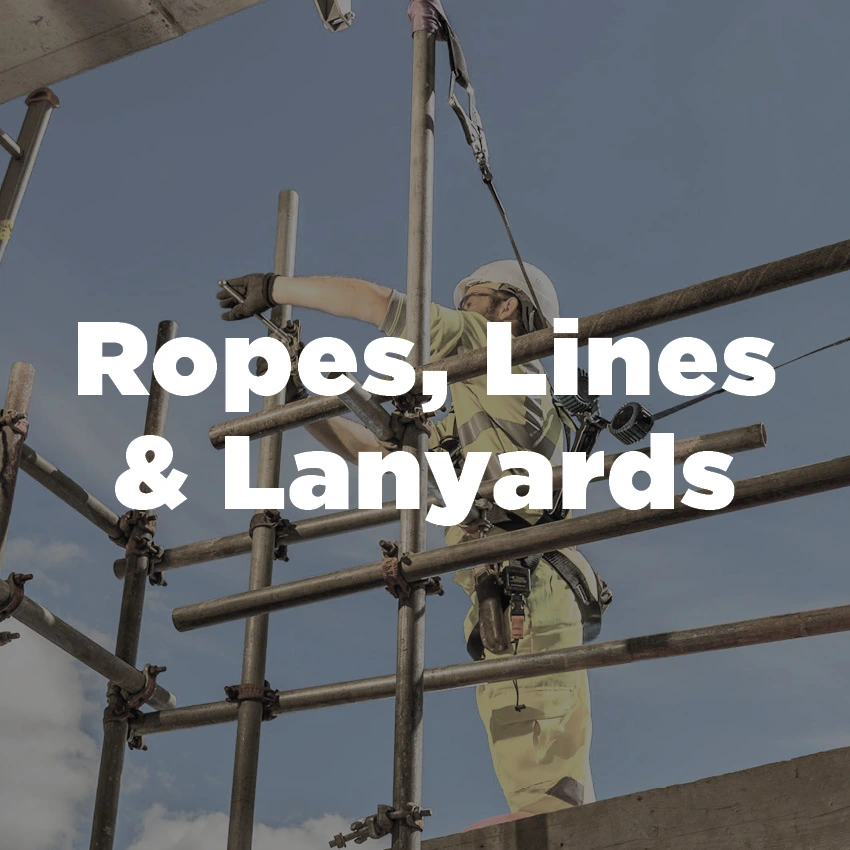 Construction worker wearing hi-vis and a helmet attached via harness to a scaffolding structure